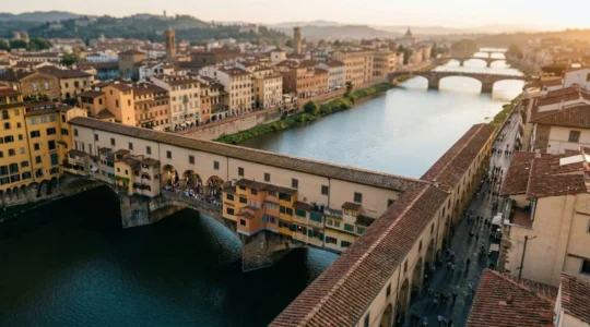 Vista panoramica di Ponte Vecchio a Firenze durante l'ora dorata con turisti che passeggiano serenamente
