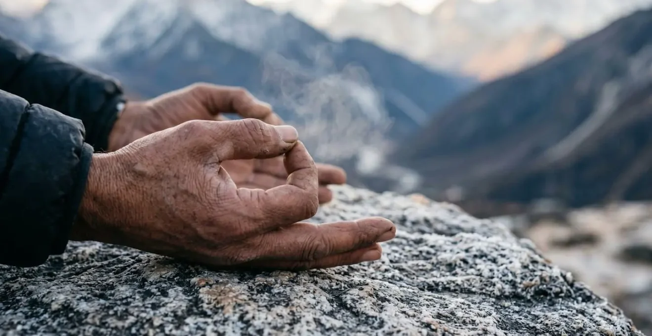 Primo piano di persona che pratica tecniche di respirazione yoga su roccia in alta quota
